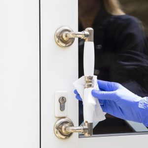 hand-with-surgical-gloves-disinfecting-door-handle